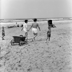 841943 Gezicht op het strand bij Wijk aan Zee, met de dames De Jonge en Van Savoijen die een strandkar voorttrekken.